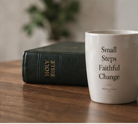 An illustrative still life of a Bible and a mug on a wooden table